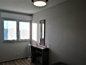 a room with a mirror and a table and a chair at T2 Centre Ville Place Méditerranée in Perpignan