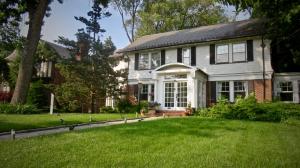 une maison blanche avec une pelouse devant elle dans l'établissement GuestHouse, à Elizabeth