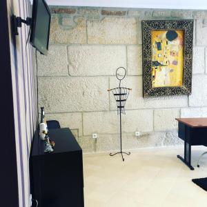 アリジョーにあるAlojamento Galerias Nascentesの壁にテレビとテーブルが備わる客室です。