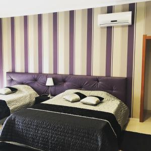 - une chambre avec 2 lits et une tête de lit violette dans l'établissement Alojamento Galerias Nascentes, à Alijó
