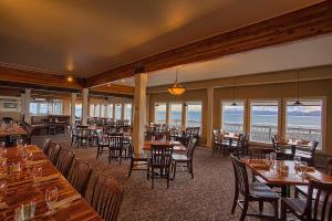 
a restaurant with tables, chairs, and tables with umbrellas at Land's End Resort in Homer
