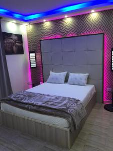 a bedroom with a large bed with a purple lighting at Apartment at Milsa Nasr City, Building No. 30 in Cairo