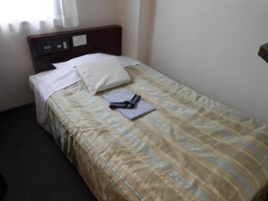 Una cama con un par de gafas. en Niigata Terminal Hotel, en Niigata