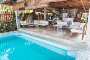 a swimming pool in front of a house with a patio at Soultribe Beach Retreat in General Luna