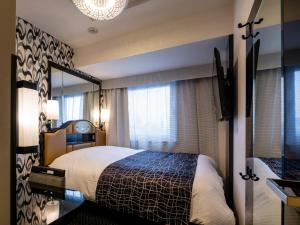 a hotel room with a bed and a mirror at APA Hotel Komagome Ekimae in Tokyo