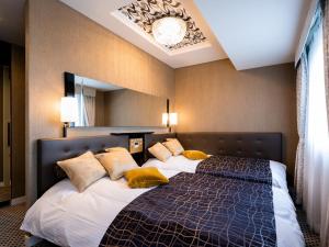a bedroom with a large bed with yellow pillows at APA Hotel Komagome Ekimae in Tokyo