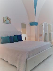 ロコロトンドにあるIl Balcone di Giuliettaの白いベッドルーム(青い枕の白いベッド付)