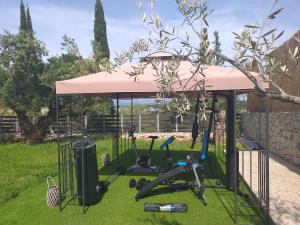a gazebo with exercise equipment in a yard at Golden Sun Villas in Nydri