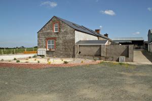 a stone house with a driveway in front of it at Aunt Rachel's Cottage in Bushmills