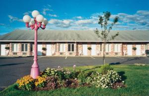 un poste de luz rosa frente a un edificio en Motel Invitation, en Sainte-Marie