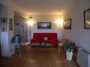 a living room with a red couch and a table at Il Bruco appartamenti in b&b in San Donato Val di Comino