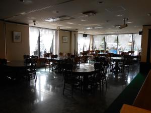 a dining room with tables and chairs and windows at Terminal Art Inn in Niigata