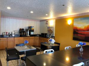 a restaurant with two tables and chairs and a kitchen at Super 8 by Wyndham Front Royal in Front Royal