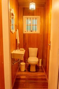 a bathroom with a toilet and a sink at Chalé Suiço in São Francisco de Paula