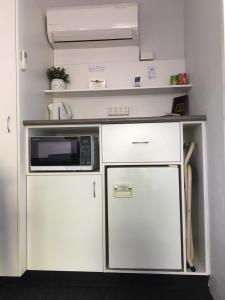 a small kitchen with a microwave and a refrigerator at Nicholas Royal Motel - No Pets Allowed in Hay
