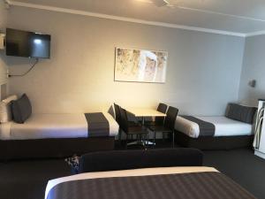 海伊Nicholas Royal Motel - No Pets Allowed的有两张床和一张桌子的酒店房间
