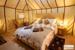 a bedroom with a large bed in a tent at Sahara Happy Camp in Merzouga