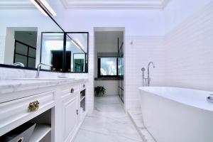 a white bathroom with a large tub and a sink at Las Casas B&B Boutique Hotel, Spa & Restaurante Cuernavaca in Cuernavaca