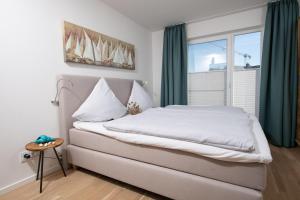 a bed in a room with a large window at Knuts Koje in Olpenitz