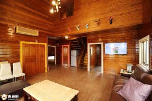 a living room with wooden walls and a couch and a tv at Lakeside Camping Resort in Gukeng