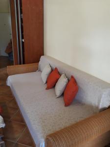 a couch with three red pillows on it at Apartment Milica in Herceg-Novi