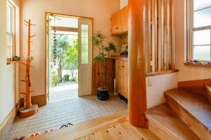 a hallway with wooden floors and a door with a plant at AbbeyRoad Inn Seika in Seika