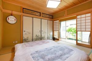 a bedroom with a large bed and a clock on the wall at AbbeyRoad Inn Seika in Seika +31 photos