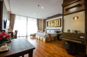 a hotel room with a bed and a living room at Khammon Lanna Resort Chiang Mai in Chiang Mai