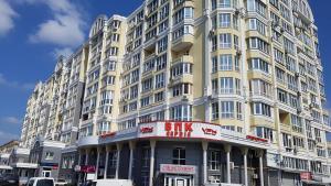 a large yellow building with a sign in front of it at Chernihiv City Apartments - Peremohy in Chernihiv