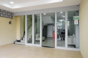 un pasillo con puertas de cristal y una escalera en una casa en RedDoorz near Plaza Atrium Senen en Yakarta