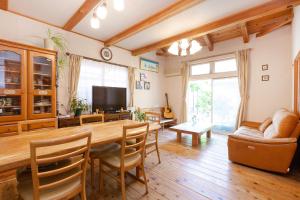 a living room with a large wooden table and chairs at AbbeyRoad Inn Seika in Seika