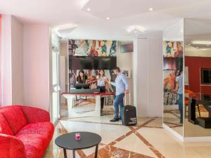 a man standing in a living room with his luggage at Mercure Paris Pont de Levallois Neuilly in Levallois-Perret