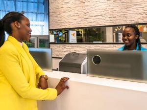 two women standing at a counter with a computer at ibis Styles - Nairobi, Westlands in Nairobi