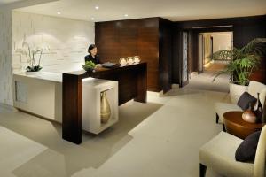 a woman sitting at a reception desk in a room at Asiana Hotel Dubai in Dubai