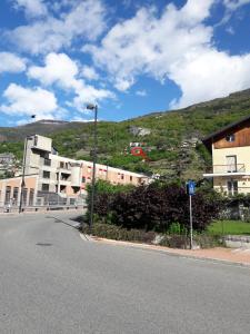 Une rue vide avec un bâtiment sur une colline dans l'établissement Appartamenti Bioula CIR Aosta n 0247, à Aoste