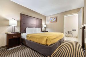 a hotel room with a large bed and a table at Econo Lodge in Florence