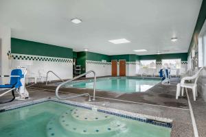a swimming pool with chairs and a table at Comfort Inn & Suites Salem Northeast in Salem