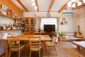 a dining room with a large wooden table and chairs at AbbeyRoad Inn Seika in Seika