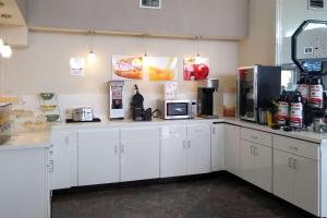 a large kitchen with white cabinets and appliances at Econo Lodge Inn & Suites West - Energy Corridor in Houston