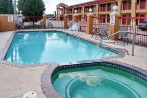 a swimming pool at a hotel with tables and chairs at Econo Lodge Inn & Suites West - Energy Corridor in Houston