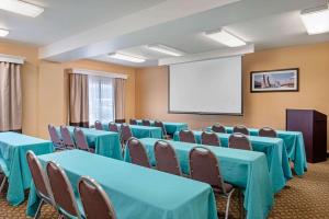 a conference room with blue tables and chairs and a white screen at Comfort Inn & Suites Salem Northeast in Salem +43 photos