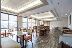 een eetkamer met tafels, stoelen en ramen bij Clarion Inn near Lookout Mountain in Chattanooga