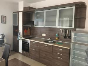 a kitchen with wooden cabinets and a sink at Apartment on the sea at St Nikolas Complex-Elena in Chernomorets