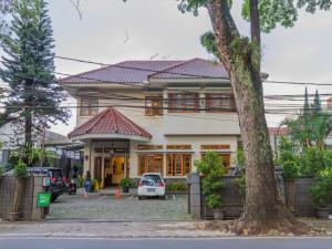 une maison avec une voiture garée devant elle dans l'établissement RedDoorz near Simpang Dago 2, à Bandung
