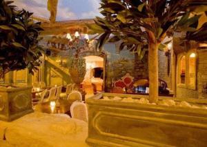 a living room with palm trees and a dining area at The Blueberry Hotel in Pontypridd