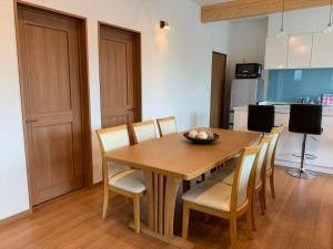 a dining room with a wooden table and chairs at Diamond Dust Furano in Furano