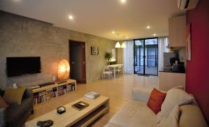 a living room with a couch and a table at Baan Mali Apartment in Chiang Mai