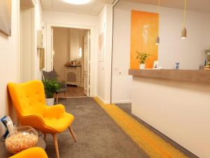 ein Wohnzimmer mit einem gelben Stuhl und einer Theke in der Unterkunft Hotel Seifert Berlin am Kurfürstendamm in Berlin