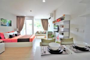 a living room with a bed and a dining room at Ozone Condotel Kata Beach by PHR in Kata Beach