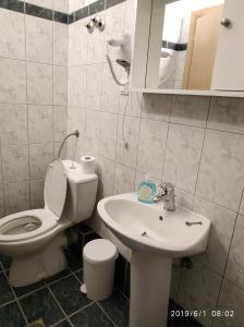 La salle de bains est pourvue de toilettes et d'un lavabo. dans l'établissement LAZAROS APARTMENTS, à Olympiakí Aktí